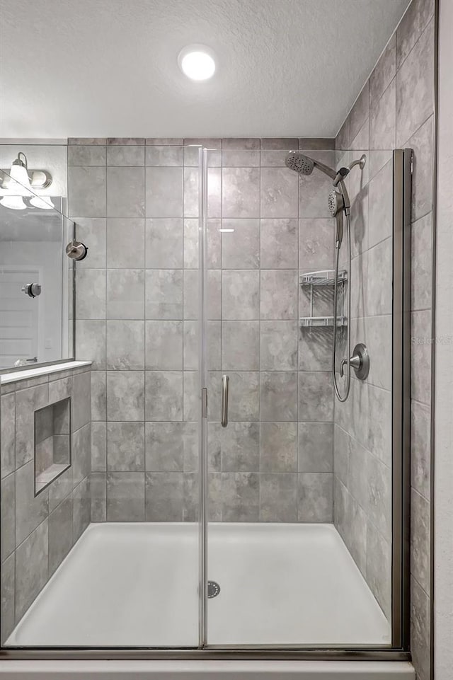 full bath with a stall shower and a textured ceiling