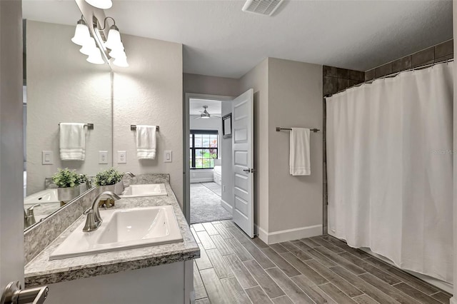 bathroom featuring double vanity, visible vents, wood finish floors, and a sink