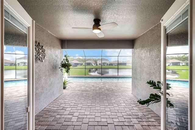 interior space with a water view and ceiling fan