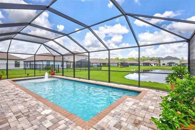 view of swimming pool with glass enclosure, a yard, and a water view