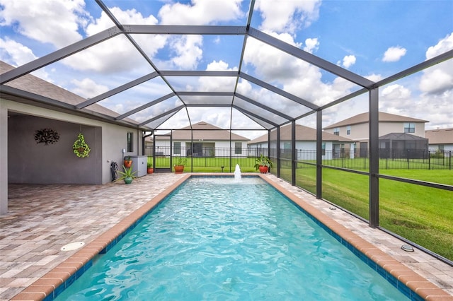 view of swimming pool featuring a lawn, pool water feature, a lanai, and a patio