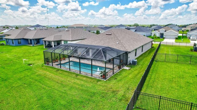 view of swimming pool with central air condition unit, a lawn, and a lanai