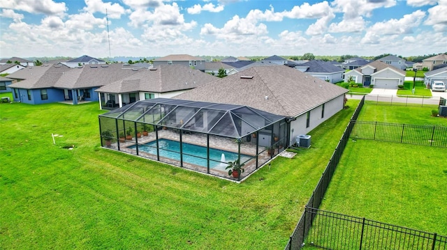 view of swimming pool with central air condition unit, fence, a yard, a residential view, and a lanai