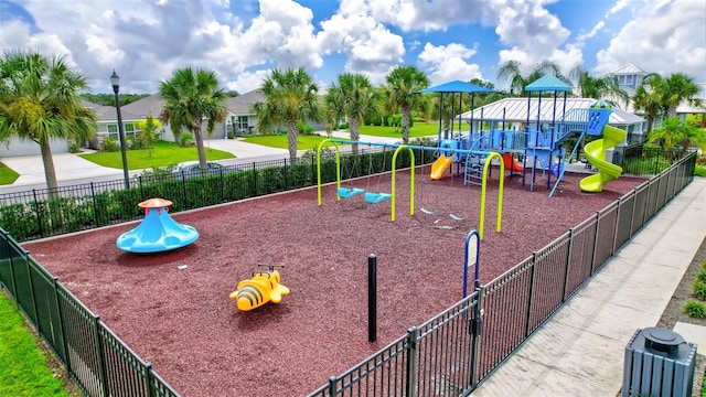 community play area featuring a yard and fence