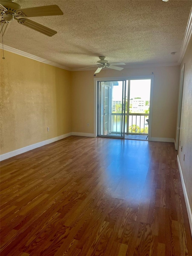 empty room with ceiling fan, ornamental molding, dark hardwood / wood-style flooring, and a textured ceiling