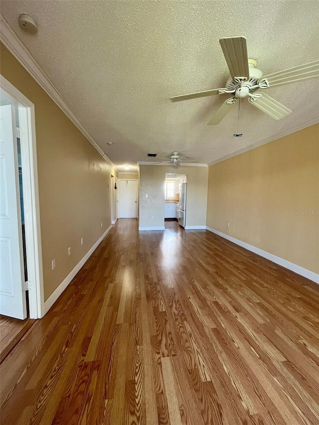 unfurnished living room with a textured ceiling, ceiling fan, ornamental molding, and wood-type flooring