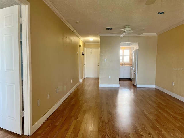 spare room featuring ornamental molding, a textured ceiling, hardwood / wood-style flooring, and ceiling fan