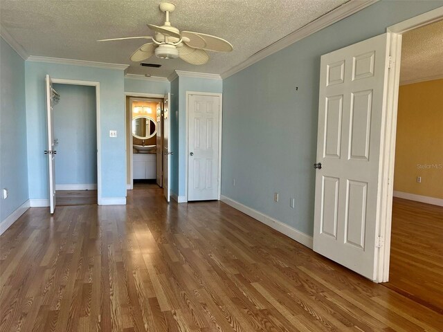 unfurnished bedroom with wood finished floors, a ceiling fan, ornamental molding, baseboards, and a textured ceiling