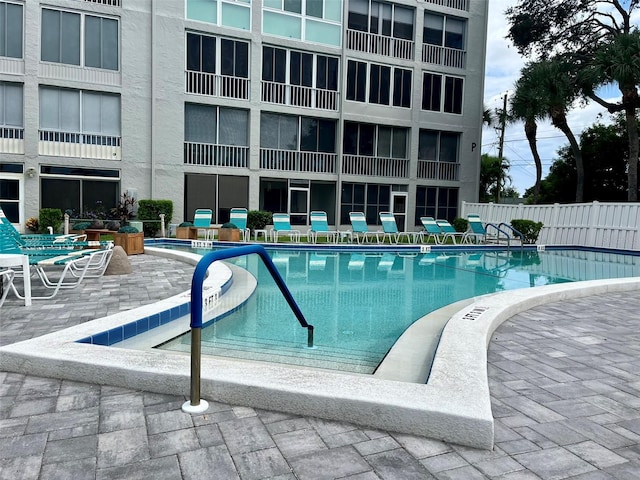 pool featuring fence and a patio