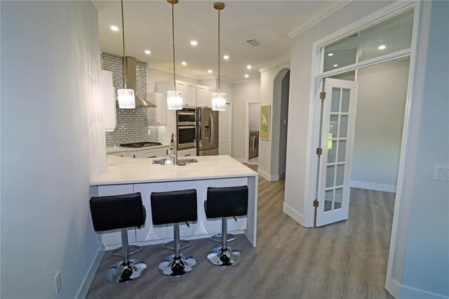 kitchen featuring light hardwood / wood-style flooring, backsplash, sink, appliances with stainless steel finishes, and white cabinets