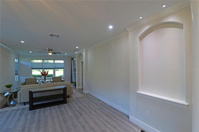 interior space featuring crown molding, wood-type flooring, and ceiling fan