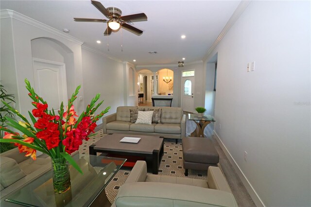 living room with ceiling fan, ornamental molding, and wood-type flooring