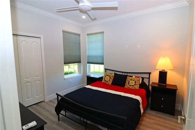 bedroom featuring a closet, ceiling fan, hardwood / wood-style flooring, and crown molding