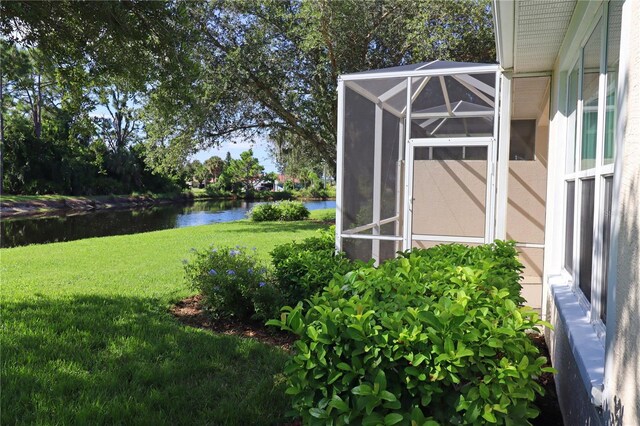 view of yard with glass enclosure and a water view