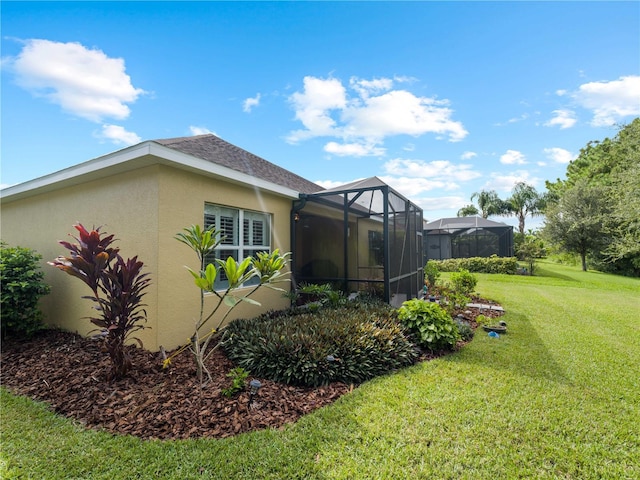 view of side of home with glass enclosure and a yard