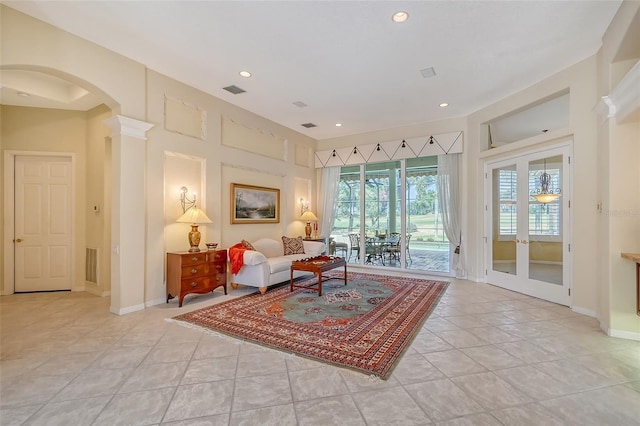 tiled living room featuring ornate columns and french doors