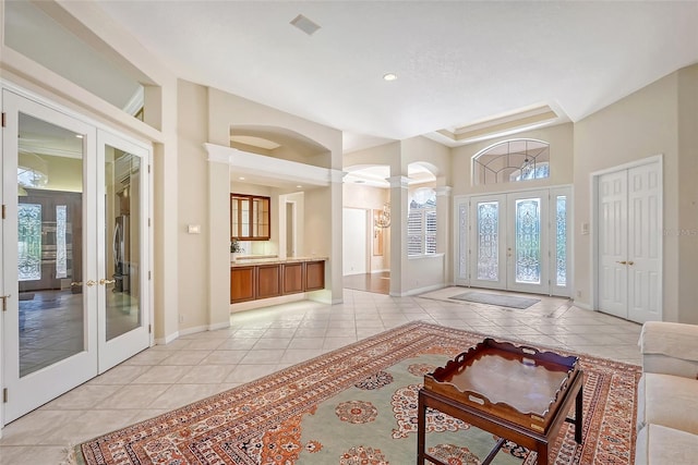 tiled entryway featuring decorative columns and french doors