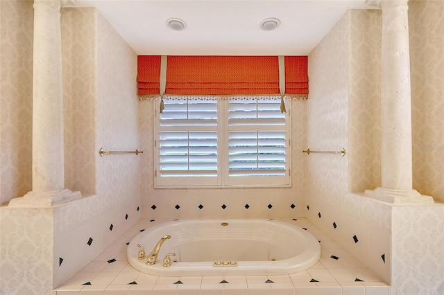 bathroom with ornate columns and a relaxing tiled tub