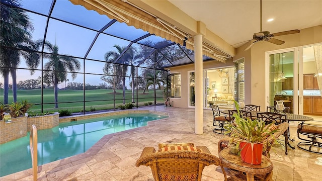 pool at dusk featuring ceiling fan, a patio, and a lanai