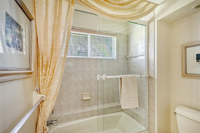 bathroom with enclosed tub / shower combo and toilet