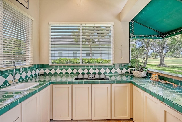 interior space featuring tile countertops, sink, and plenty of natural light