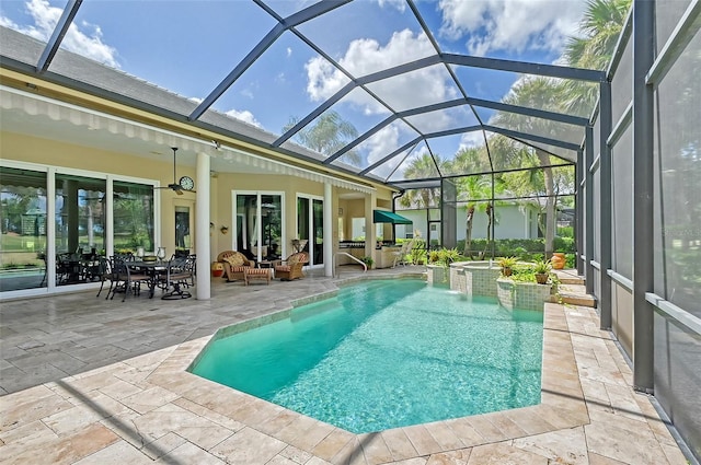 view of pool with glass enclosure, a jacuzzi, pool water feature, and a patio