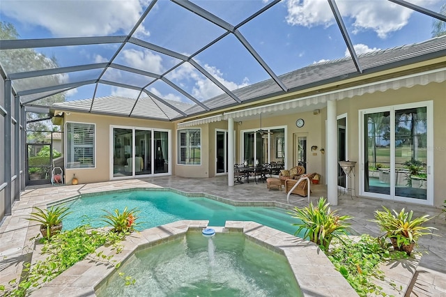 back of house featuring glass enclosure, a pool with hot tub, and a patio