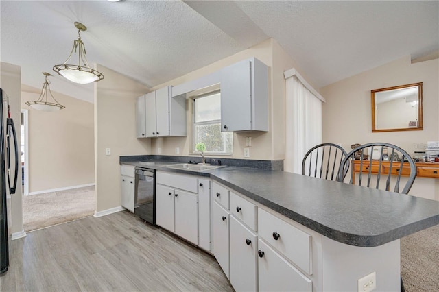 kitchen featuring black dishwasher, sink, white cabinets, kitchen peninsula, and decorative light fixtures