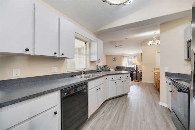 kitchen with white cabinets, dishwasher, vaulted ceiling, and sink