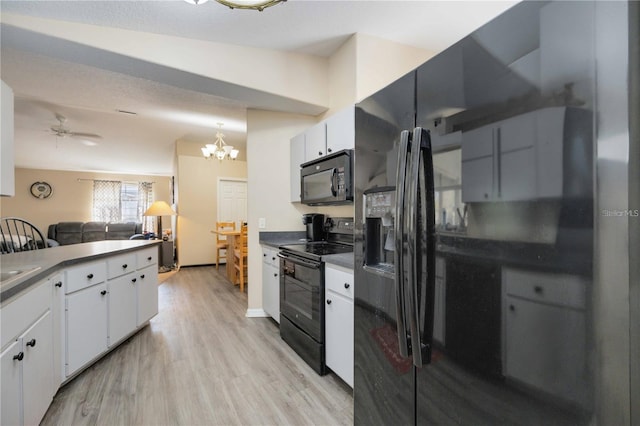 kitchen featuring ceiling fan with notable chandelier, white cabinets, black appliances, and light hardwood / wood-style floors