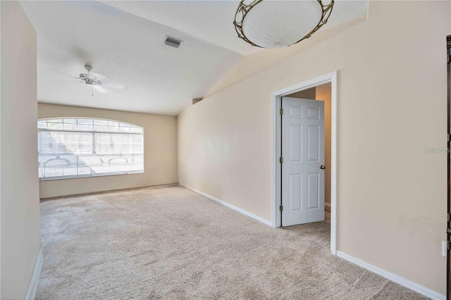 carpeted spare room with ceiling fan and vaulted ceiling