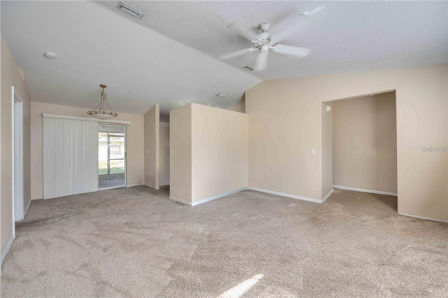 carpeted spare room with ceiling fan with notable chandelier and vaulted ceiling