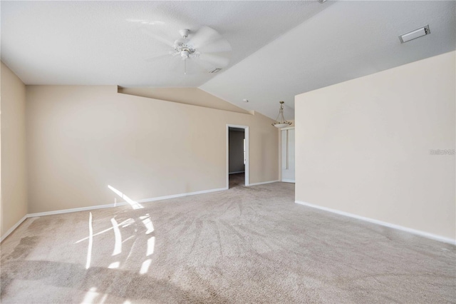 spare room featuring ceiling fan, light colored carpet, and vaulted ceiling