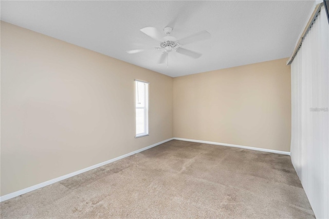 carpeted empty room featuring ceiling fan