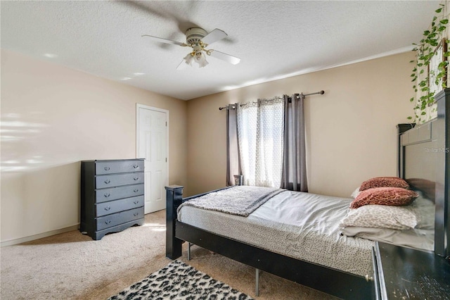 bedroom featuring a textured ceiling, light carpet, and ceiling fan