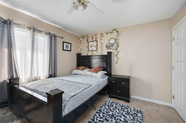 bedroom with ceiling fan, a textured ceiling, carpet, and multiple windows