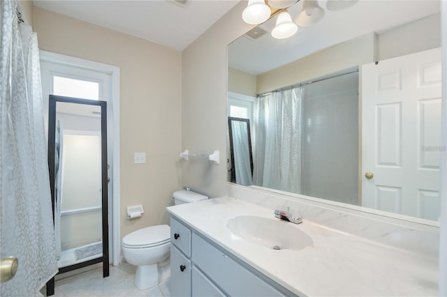 bathroom with vanity, tile patterned flooring, toilet, and a healthy amount of sunlight