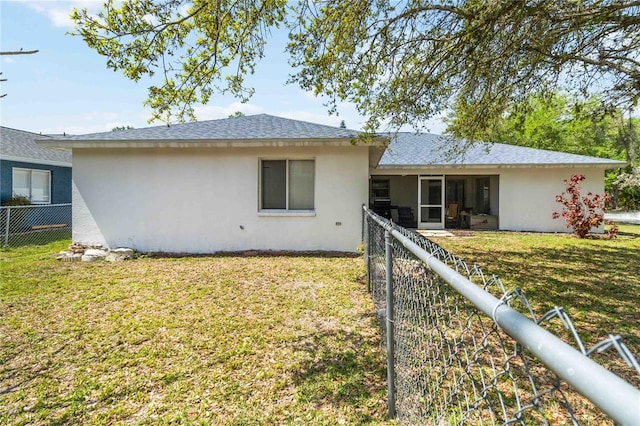 rear view of property featuring a yard