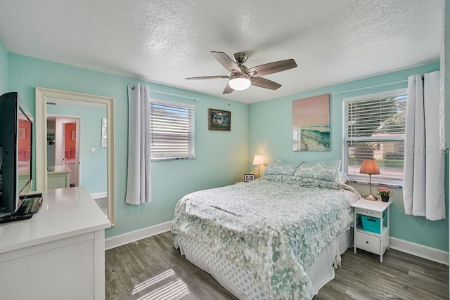 bedroom featuring dark hardwood / wood-style flooring, ceiling fan, and a textured ceiling