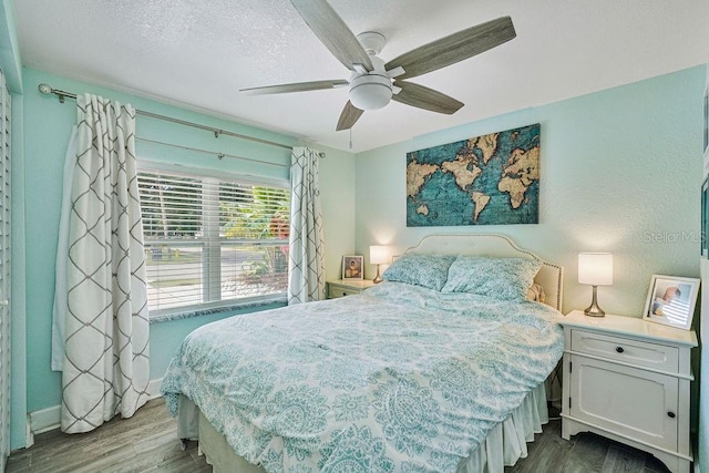 bedroom with hardwood / wood-style floors, a textured ceiling, and ceiling fan