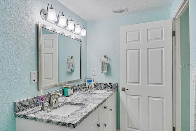 bathroom featuring vanity and a textured ceiling