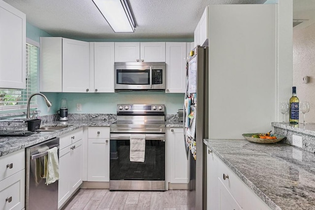 kitchen with sink, white cabinets, and appliances with stainless steel finishes