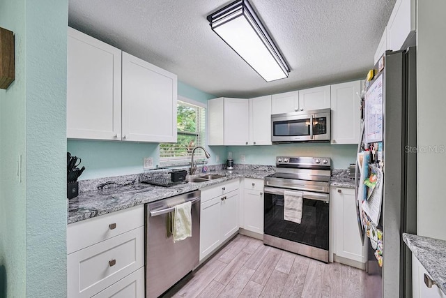 kitchen featuring appliances with stainless steel finishes, sink, and white cabinets