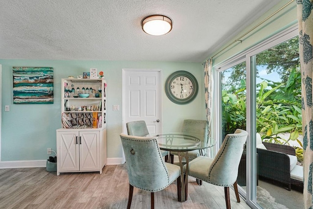 dining area featuring hardwood / wood-style floors and a textured ceiling