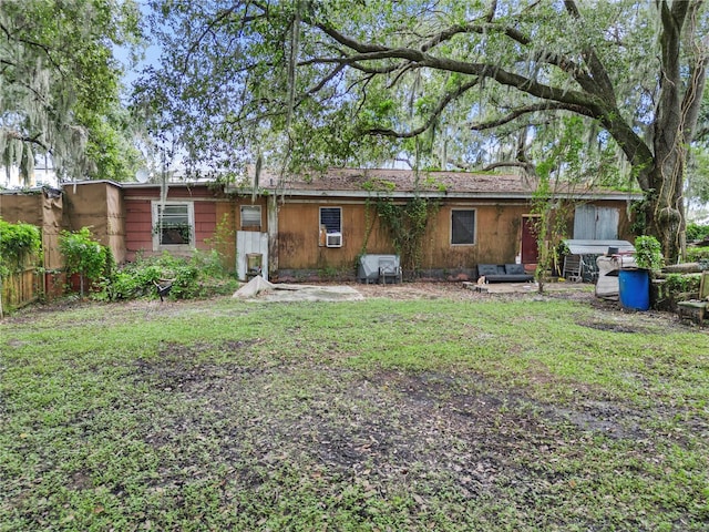 back of house featuring a lawn and cooling unit