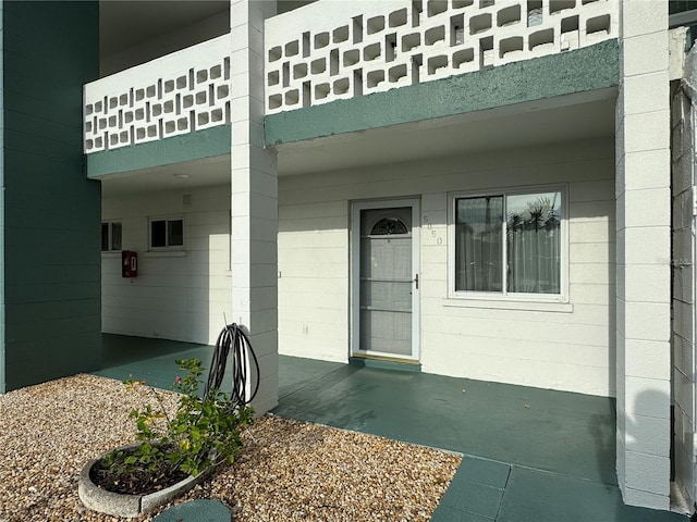 entrance to property featuring a patio and a balcony