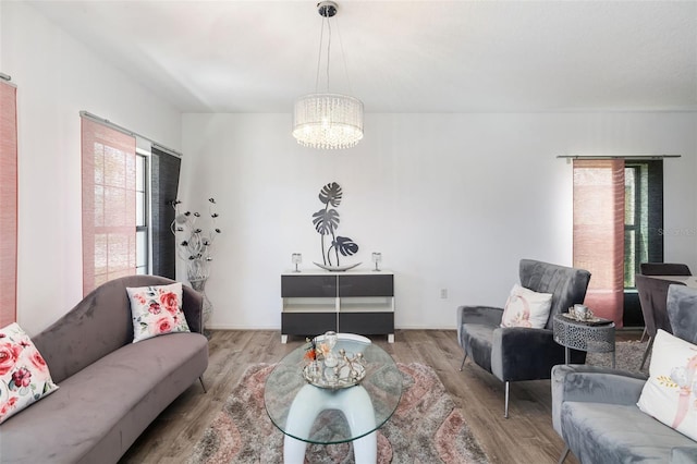 living room with an inviting chandelier, plenty of natural light, and wood-type flooring