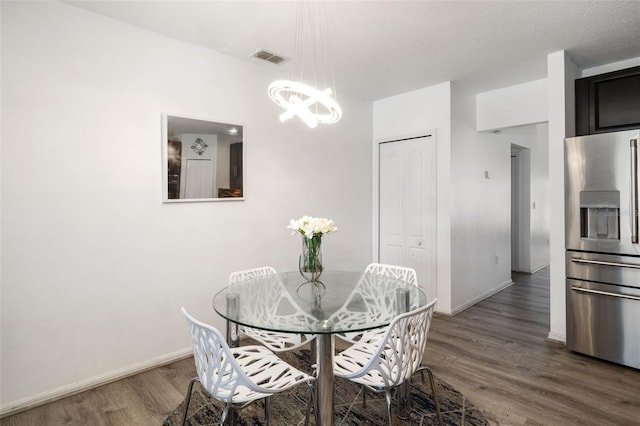 dining room with an inviting chandelier, dark hardwood / wood-style flooring, and a textured ceiling