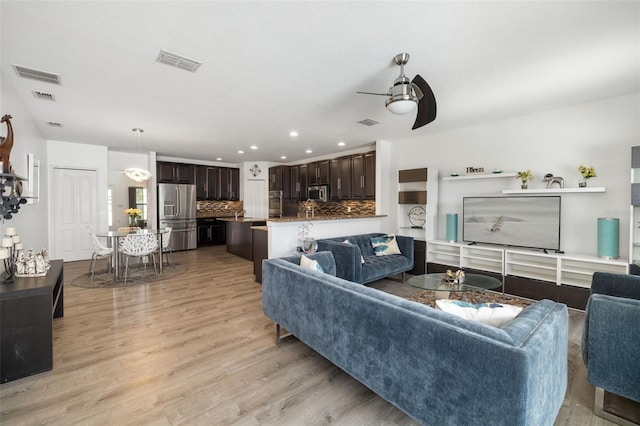 living room with ceiling fan and light hardwood / wood-style floors