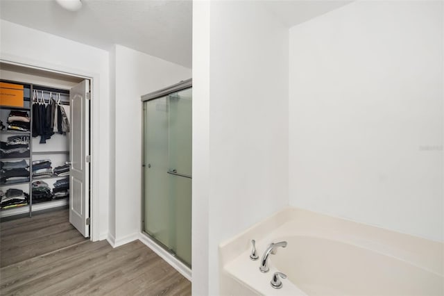 bathroom featuring a textured ceiling, hardwood / wood-style flooring, and independent shower and bath